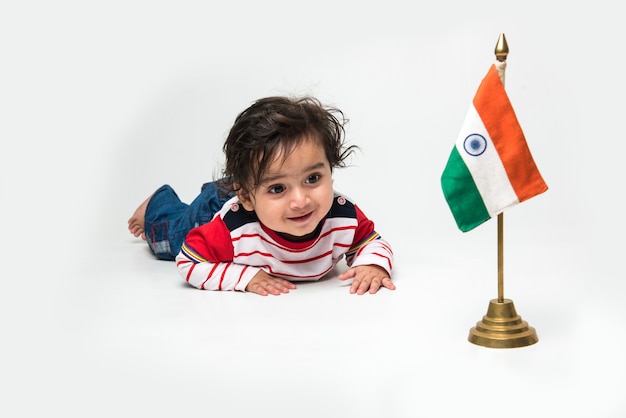 Indian cute little baby boy or infant or toddler with Indian Tricolour Flag, isolated over white background