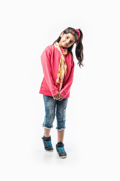 Indian cute little girl in winter wear, standing against white background