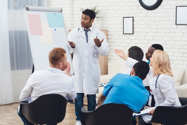 Indian doctor advises colleagues during a medical meeting.