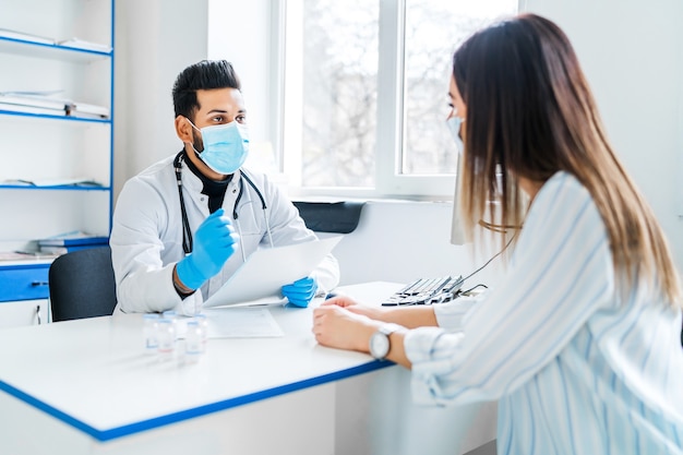 An Indian doctor consults his patient, he is in a protective mask and gloves