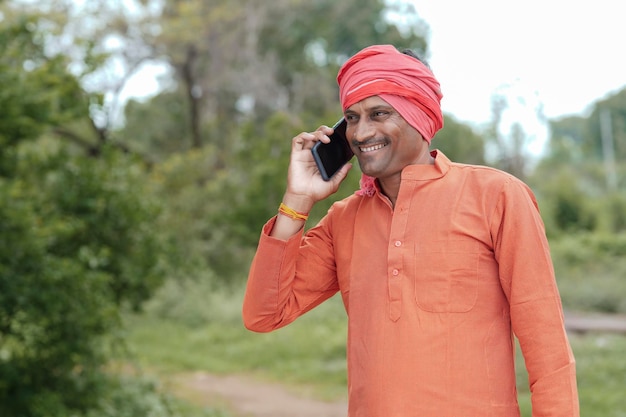 Indian farmer talking on mobile phone at Agriculture field