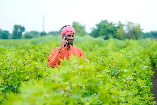 Indian farmer talking on smartphone at agriculture field