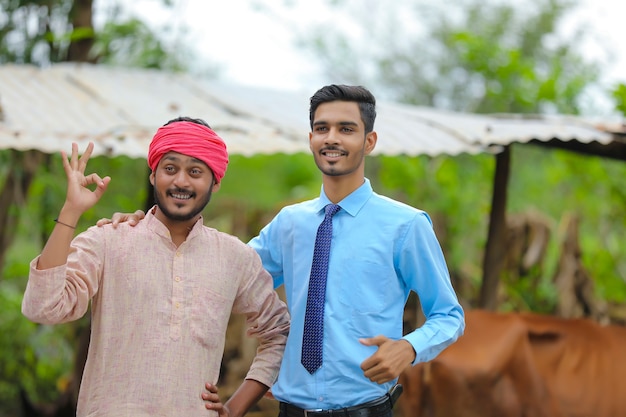 Indian farmer with agronomist at his cattle farm