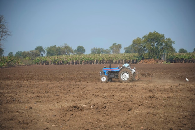 Indian farmer working with tractor in agriculture field.