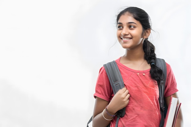 indian female college student holding books and smiling at camera