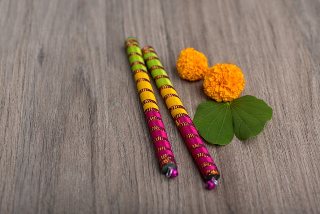 Indian Festival Dussehra and Navratriand marigold flowers with Dandiya sticks on a wooden background