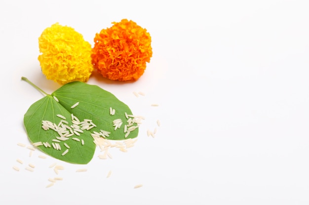 Indian Festival Dussehra showing golden leaf Piliostigma racemosum and marigold flowers on white background