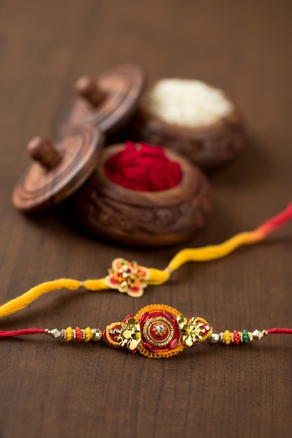 Indian festival: Raksha Bandhan background with an elegant Rakhi, Rice Grains and Kumkum