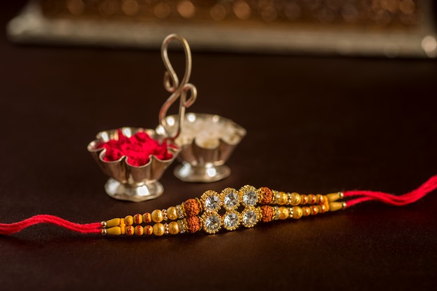 Indian festival: Raksha Bandhan with an elegant Rakhi, Rice Grains and Kumkum. A traditional Indian wrist band which is a symbol of love between Brothers and Sisters.