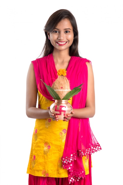 Indian girl holding a traditional copper Kalash, Indian Festival, copper Kalash with coconut and mango leaf with floral decoration, essential in Hindu Pooja.