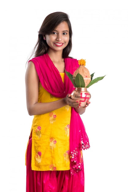 Indian girl holding a traditional copper Kalash, Indian Festival, copper Kalash with coconut and mango leaf with floral decoration, essential in Hindu Pooja.