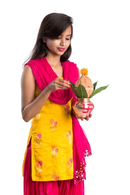 Indian girl holding a traditional copper Kalash with pooja thali