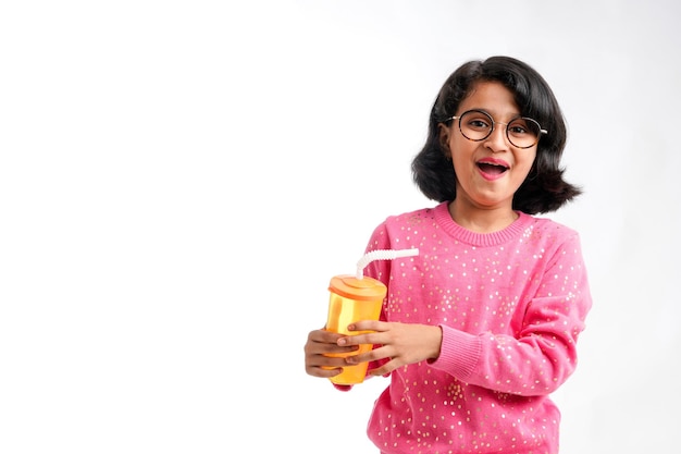 Indian happy little girl drinking juice