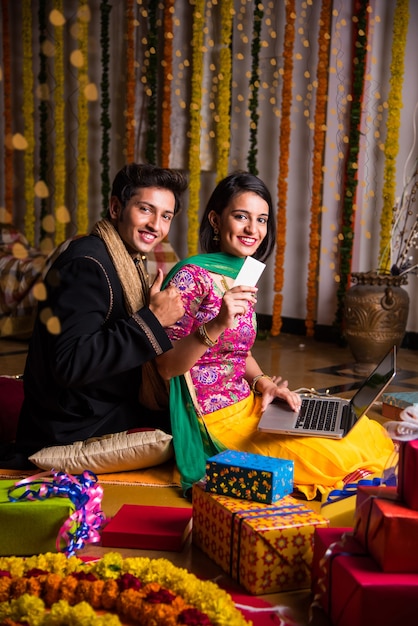 Indian husband tying or presenting necklace to his beautiful wife to celebrate anniversary of Diwali festival