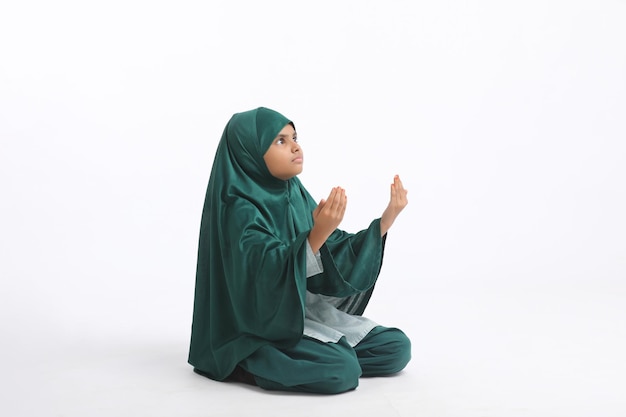 Indian islamic religious girl praying on white background