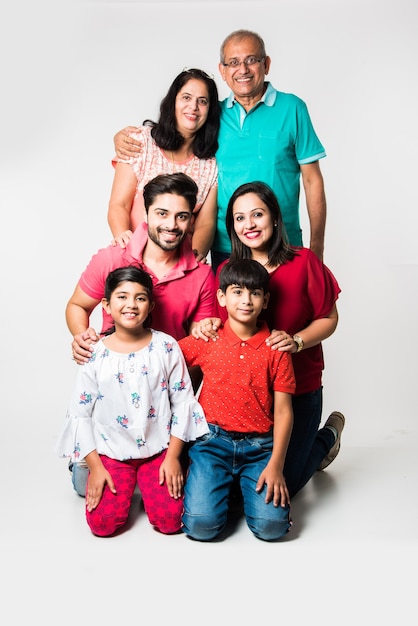 Indian Kids with parents and grandparents, sitting isolated over white background, studio shot