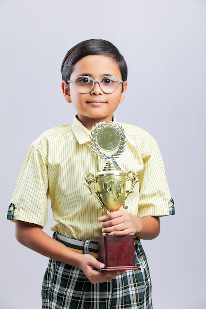 Indian little school boy giving expression with trophy