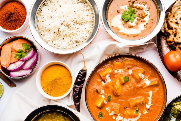 Indian Lunch or Dinner main course food in group includes Paneer Butter Masala, Dal Makhani, Palak Paneer, Roti, Rice etc, Selective focus