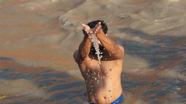 Indian man doing suryanamaskar in river ganga