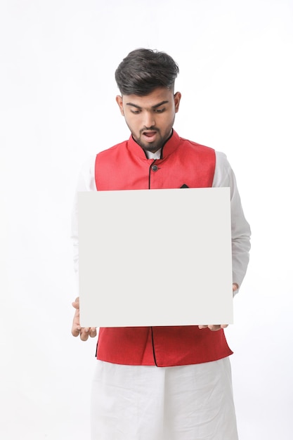 Indian man holding white board, promoting offers on festival season while wearing traditional cloths, standing over white background.