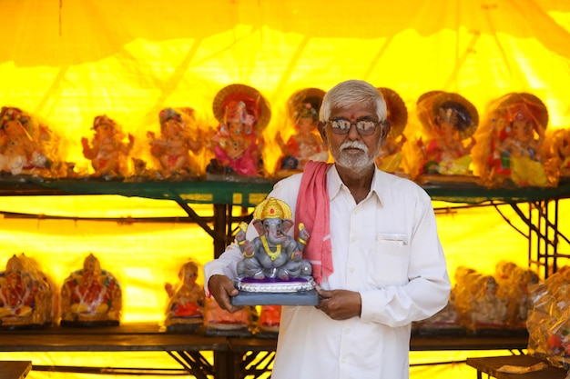 Indian man selling ganesha sculpture