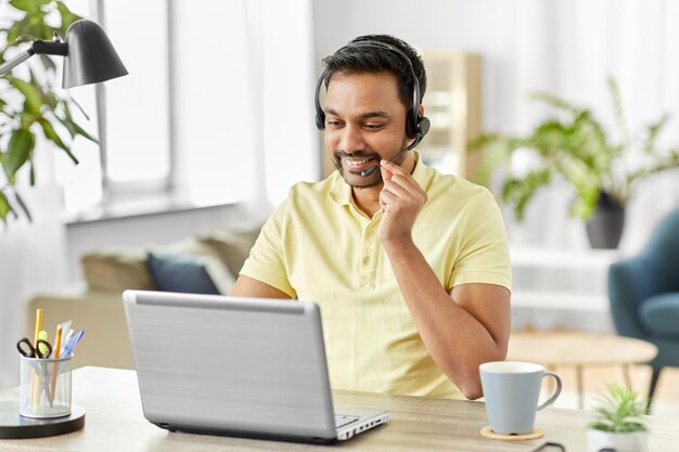 Photo indian man with headset and laptop working at home