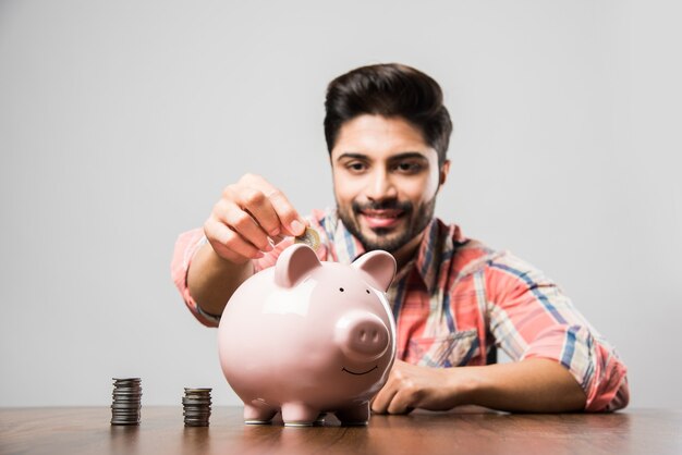 Indian Man with Piggy Bank, sitting at table