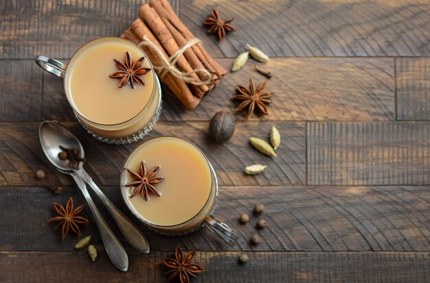 Photo indian masala chai tea. spiced tea with milk in the vintage cups on the rustic wooden tabl