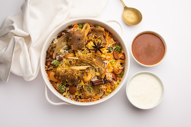 Indian Mutton biryani prepared in Basmati Rice served with Yogurt dip over moody background, Selective focus