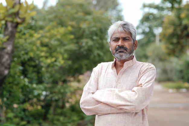 Indian old man giving expression on nature background