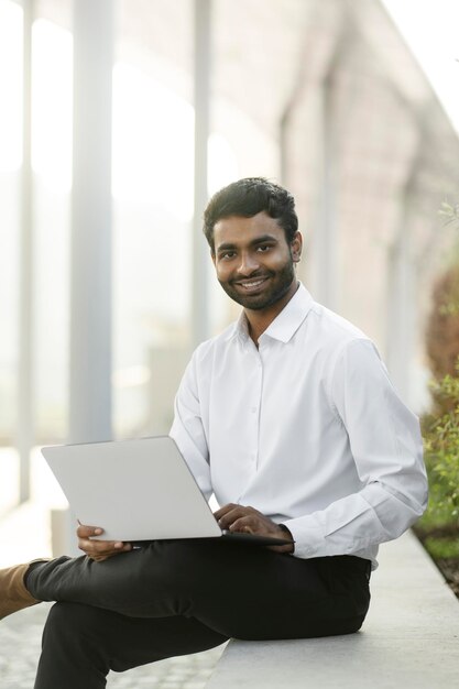 Indian programmer using laptop working online at workplace. Businessman watching training courses