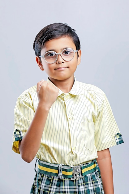 Indian school boy giving winning gesture on white background