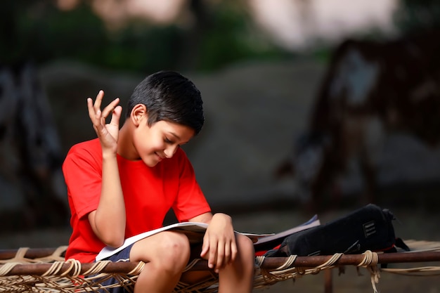 Indian school boy with note book and studying at home