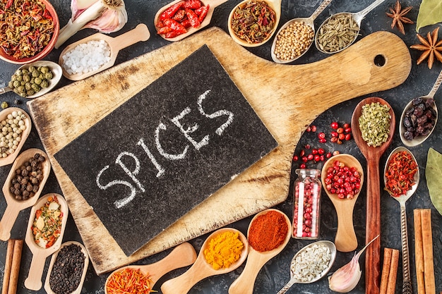 Photo indian spices, herbs and empty cutting board on black 