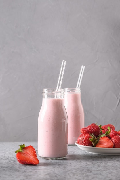 Indian strawberry lassi or milkshake in bottle on gray