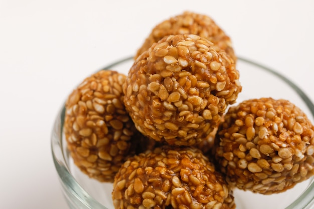 Photo indian sweet sesame seeds ball or called in hindi til ke laddu in glass bowl