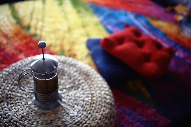 Indian tea / Indian tea concept in a glass teapot against a background of bright carpet in paints of holi, a national Indian drink