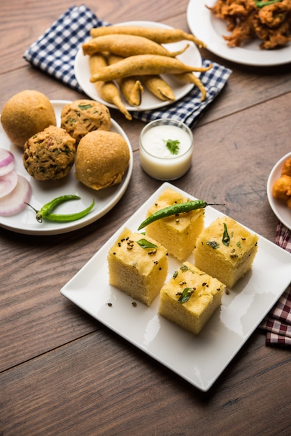 Indian Tea time snacks  in group includes Veg Samosa, Kachori, kachaudi, aloo bonda, khaman dhokla, bread, onion,chilli and moong pakora, pakoda, bhaji, bhajji,Bhajiya,bajji with sauces