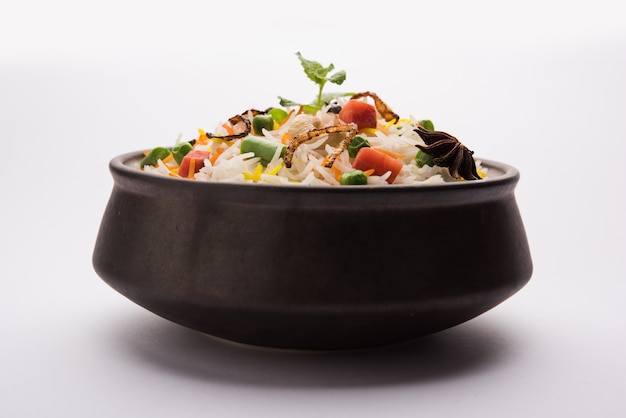 Indian Vegetable Pulav or Biryani made using Basmati Rice, served in terracotta bowl. selective focus