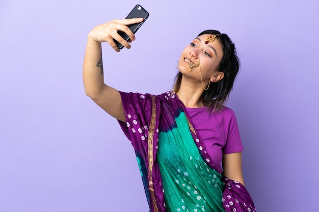 Photo indian woman isolated on purple making a selfie