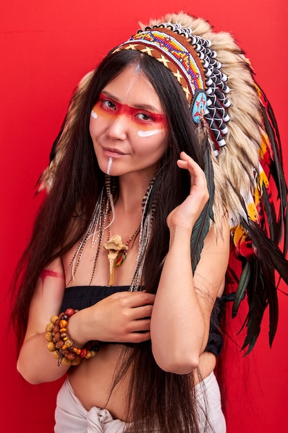 Indian woman in shamanic costume posing, having shy smile