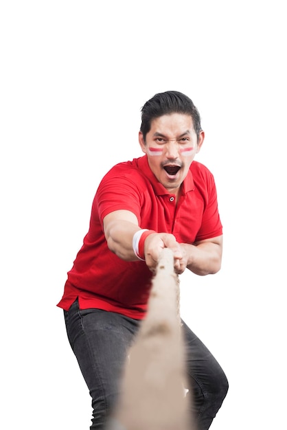 Indonesian men celebrate Indonesian independence day on 17 August with the tug of war contest