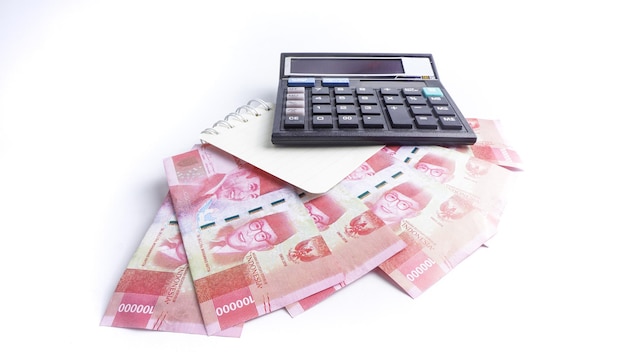 Indonesian Rupiah Banknotes calculator and book on white background