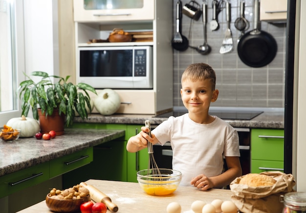 Indoor activity. Young child boy cooking in the kitchen. Doing cakes or biscuits