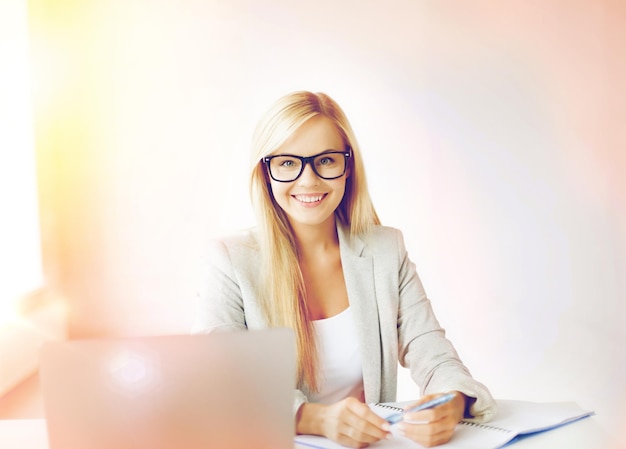 indoor picture of smiling woman with documents and pen