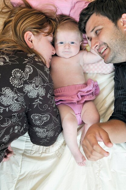 indoor portrait with happy young family and  cute little babby