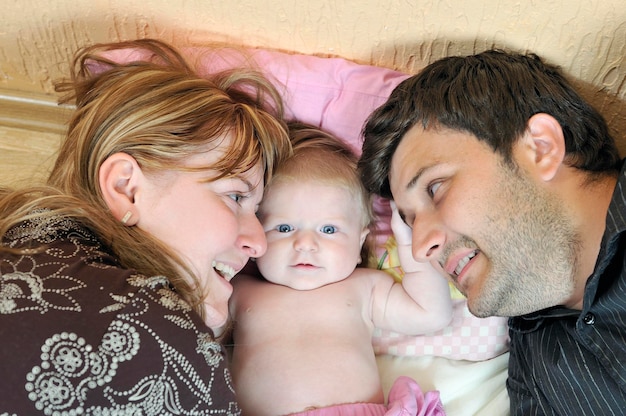 indoor portrait with happy young family and  cute little babby