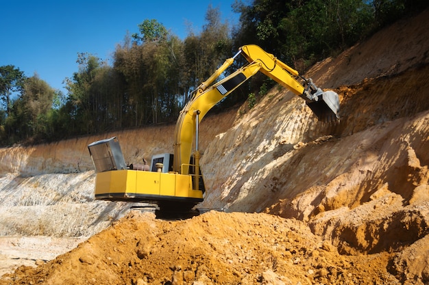 Industrial excavator working on construction site to clear the land of sand and soil