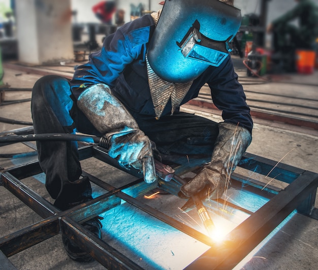 Industrial Worker labourer at the factory welding steel structure