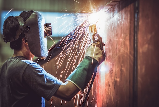 Industrial Worker labourer at the factory welding steel structure